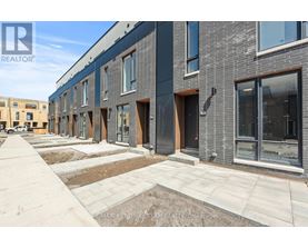 A row of new townhouses with a realtor logo in the corner.