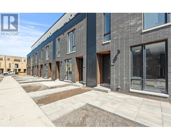 A row of new townhouses with a realtor logo in the corner.