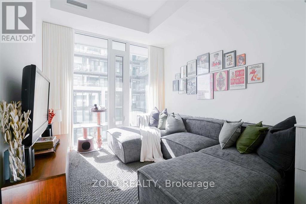A living room with a grey couch and a television.