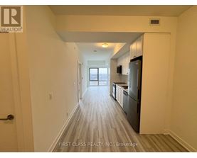 A long hallway with wood floors and white walls.