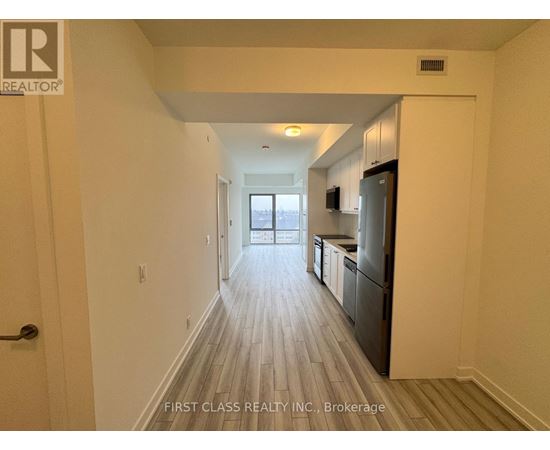 A long hallway with wood floors and white walls.