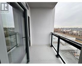 A balcony with a view of a parking lot and buildings.
