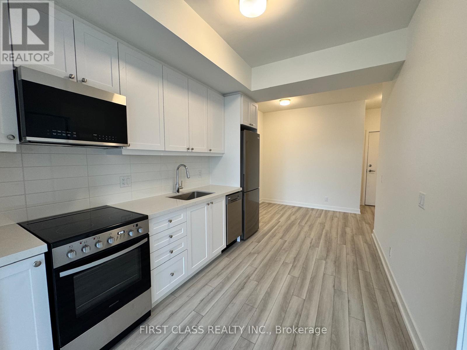 A kitchen with black appliances and white cabinets.