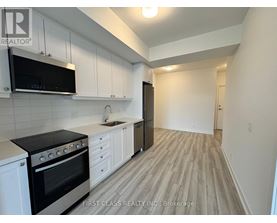 A kitchen with black appliances and white cabinets.