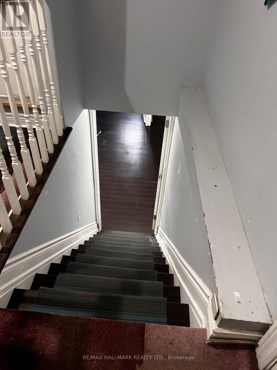 A staircase with a red carpet at the bottom.
