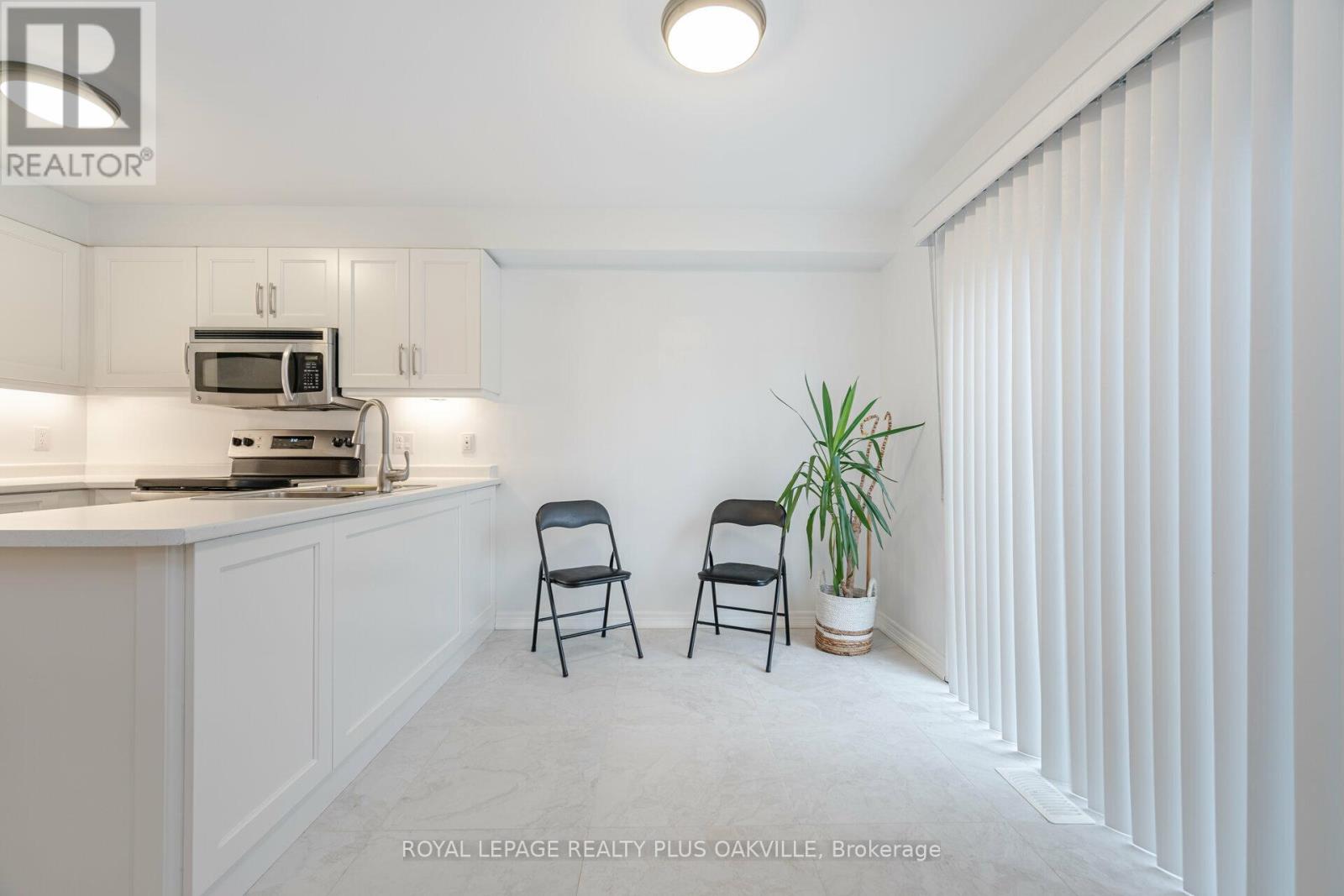 A white kitchen with a microwave and oven built into the cabinetry.