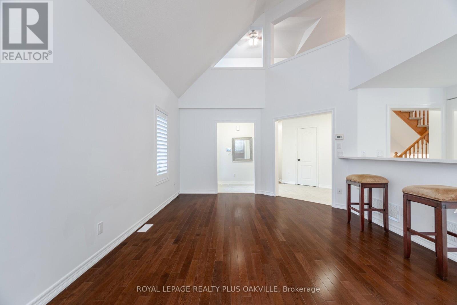A spacious room with wooden floors and white walls.