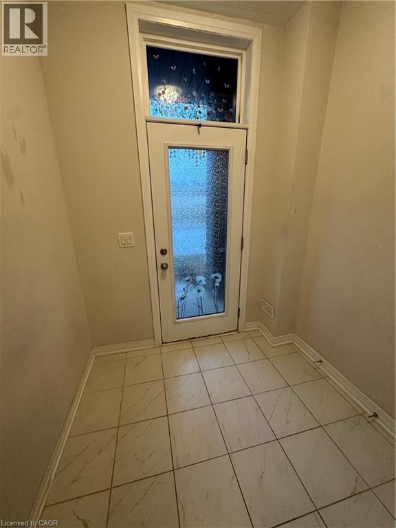 A door with a glass window in a room with tiled flooring.