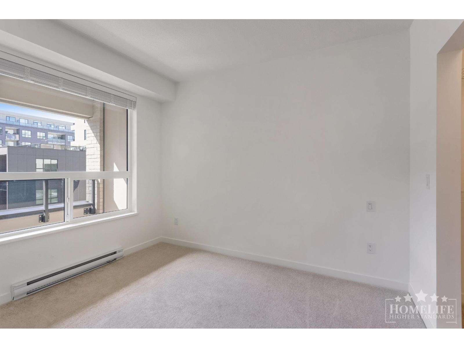A spacious, empty room with a window overlooking a cityscape.