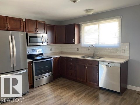 A kitchen with wooden cabinets and stainless steel appliances.