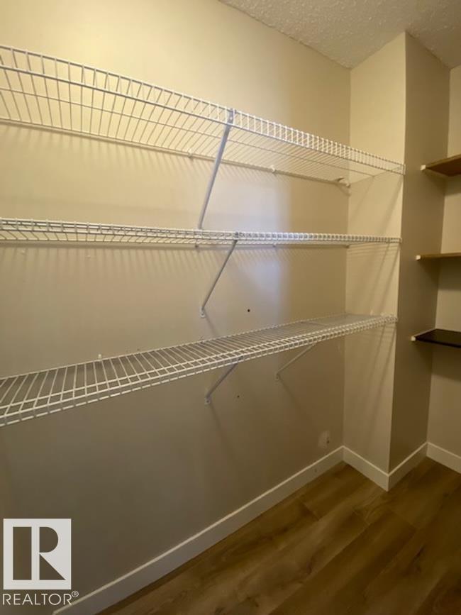 Empty white shelves in a room with wood flooring.