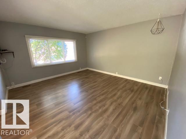 A room with wooden flooring and a window letting in natural light.