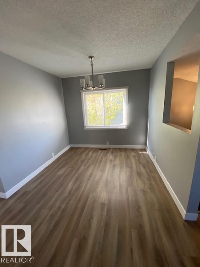 A room with wooden flooring and a window letting in natural light.