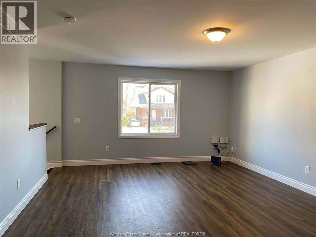 A room with a window and wooden flooring.