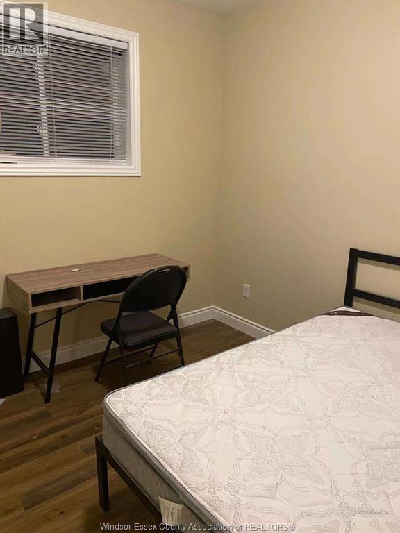 A bedroom with a bed, desk, and chair.