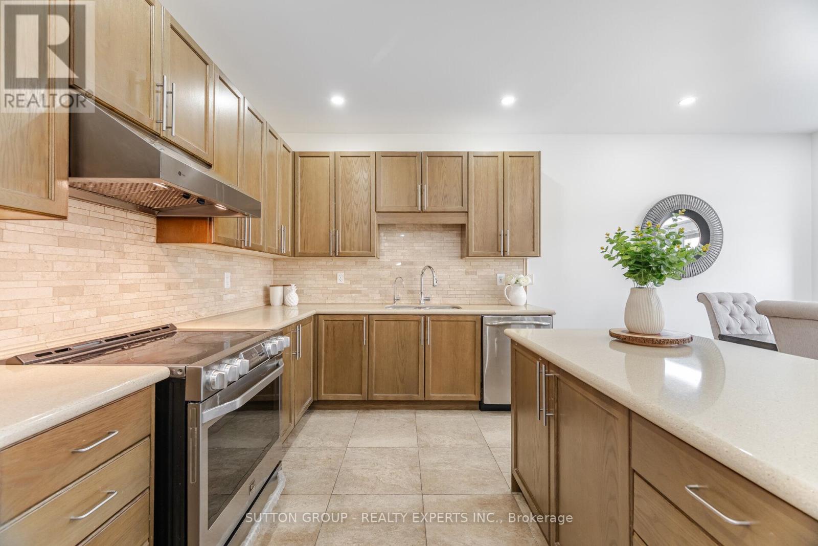 A modern kitchen with wooden cabinets and a stainless steel range hood.