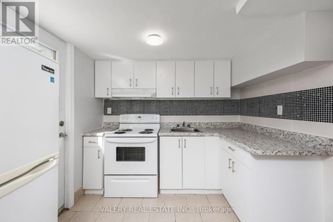 A kitchen with white appliances and cabinets.