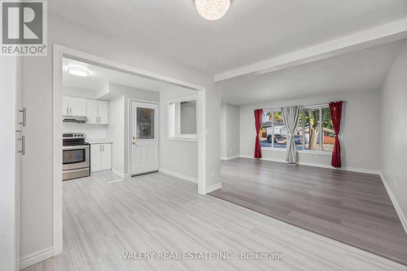 A spacious room with a kitchen area and a living room with a couch and a window.