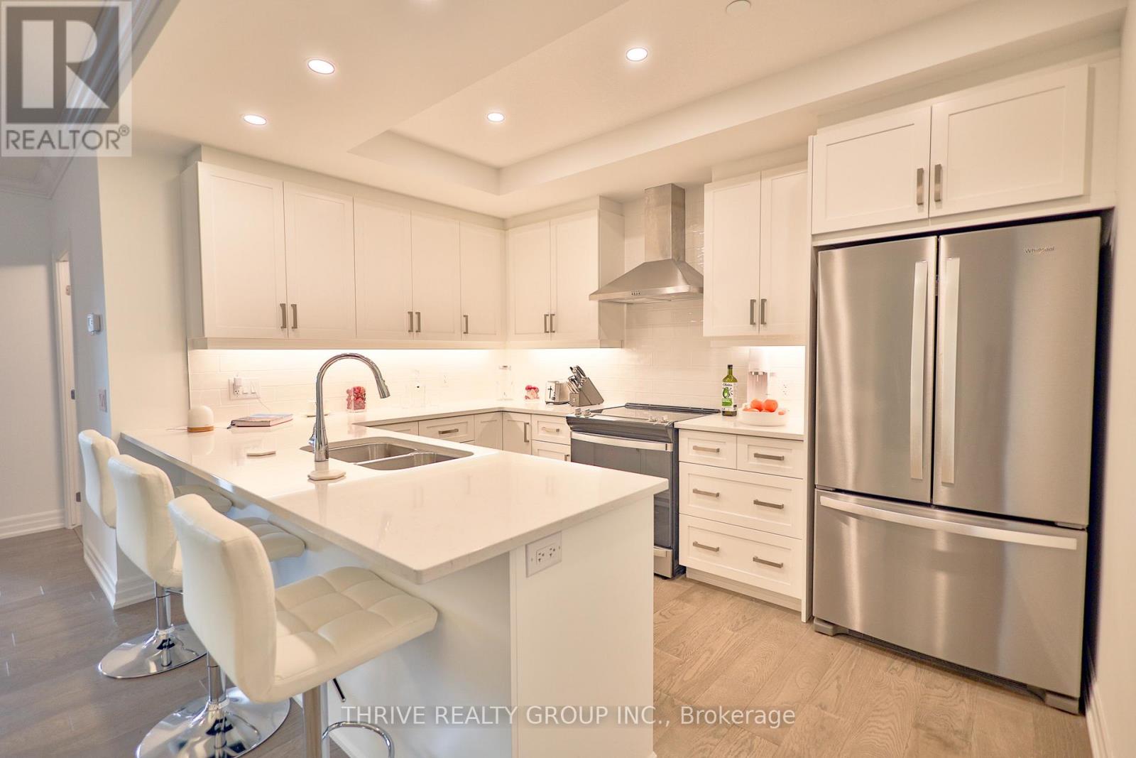 A modern kitchen with white cabinets and stainless steel appliances.