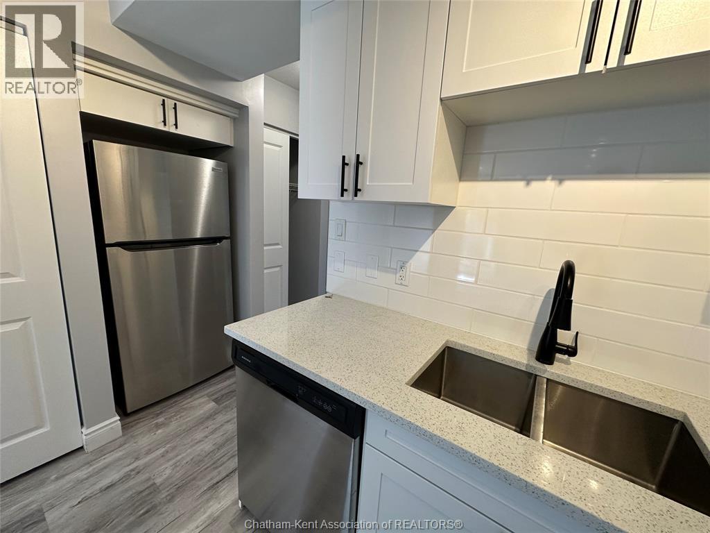 A kitchen with a stainless steel refrigerator and a sink.