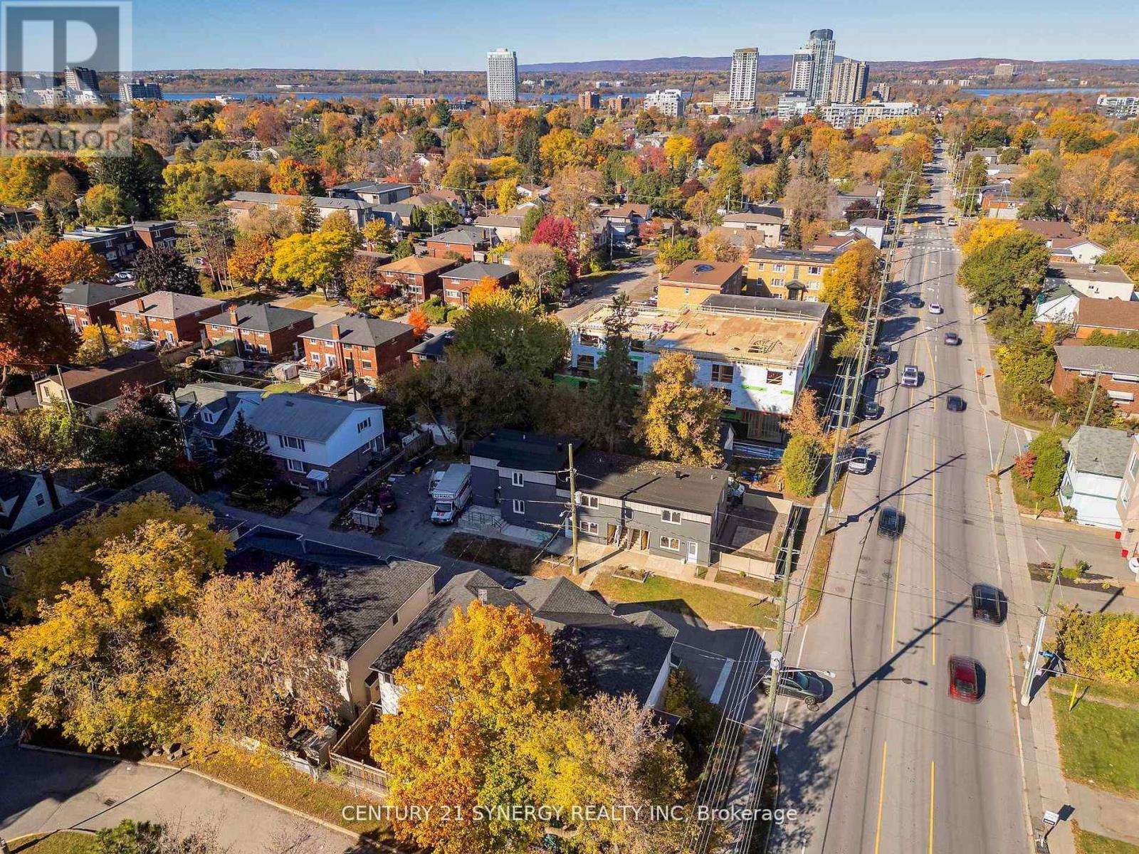 A street view of a residential area with houses and trees.