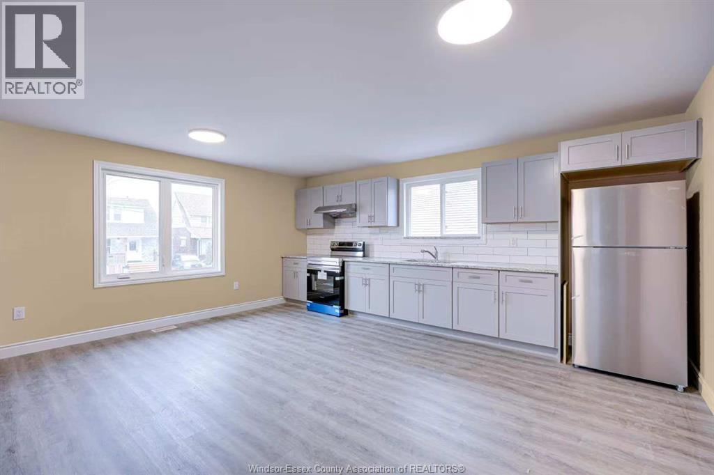 A kitchen with a refrigerator, dishwasher, and oven.