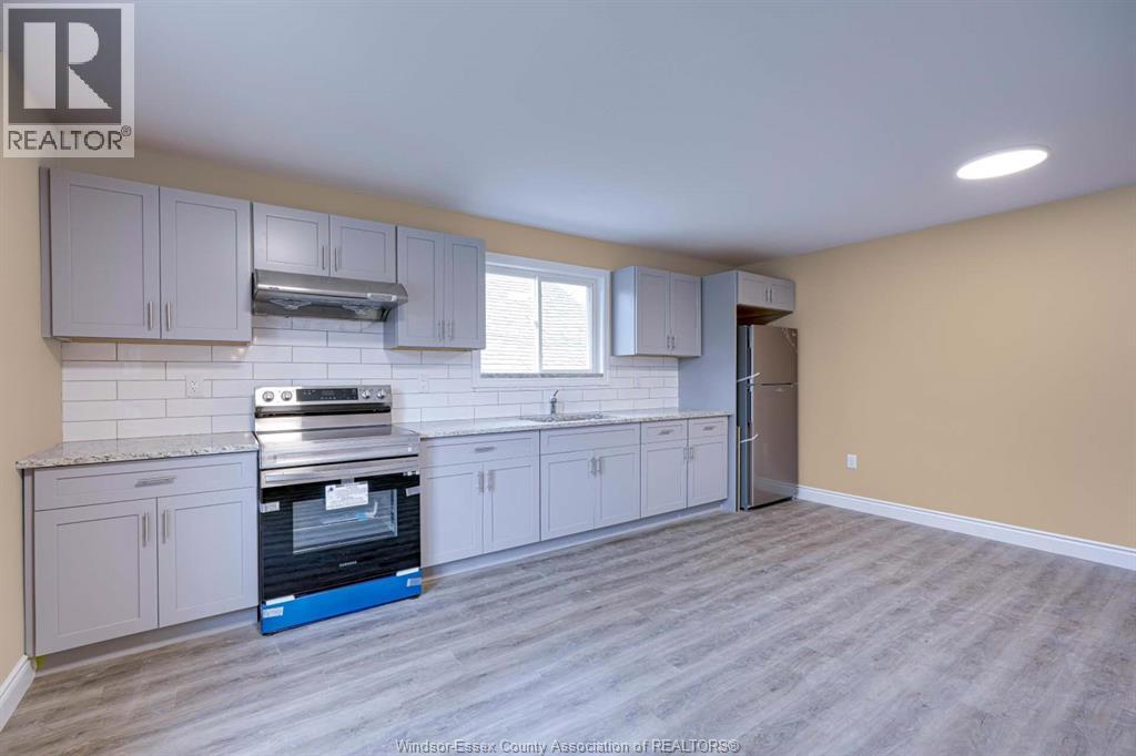 A kitchen with a stove top oven and a refrigerator.