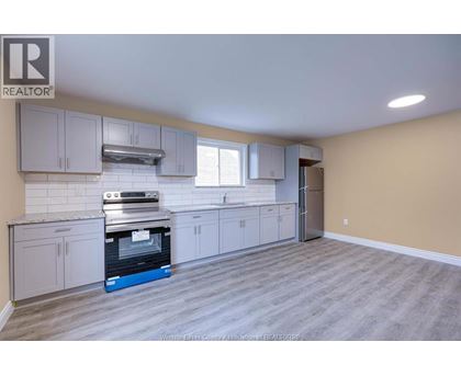 A kitchen with a stove top oven and a refrigerator.