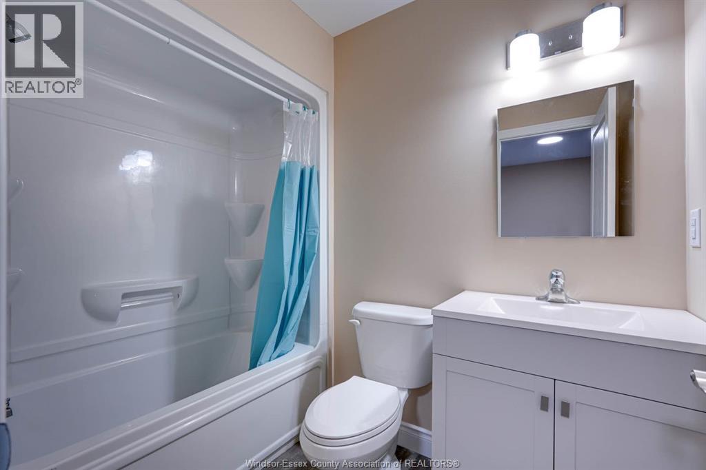 A bathroom with a toilet, sink, and shower.