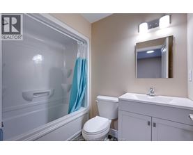 A bathroom with a toilet, sink, and shower.