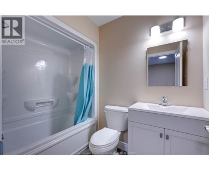 A bathroom with a toilet, sink, and shower.