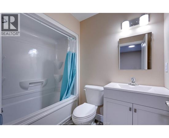 A bathroom with a toilet, sink, and shower.