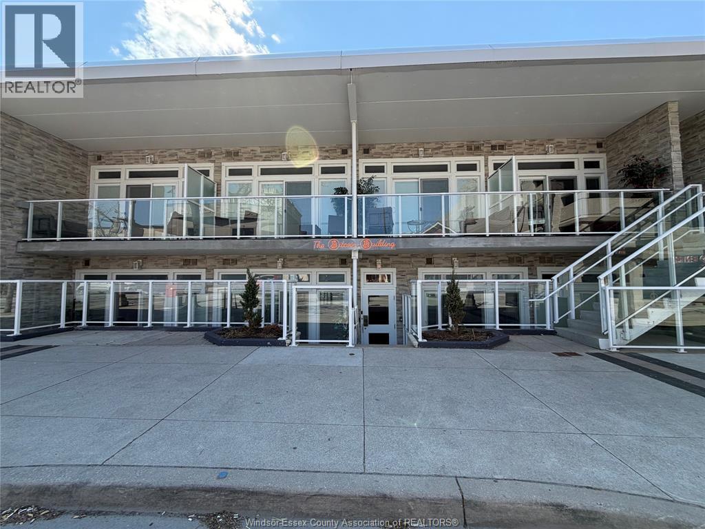A building with a balcony and a glass door in front.