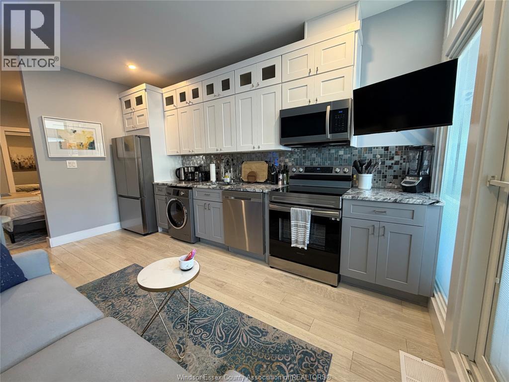 A kitchen with a grey and white color scheme.