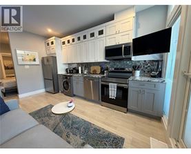 A kitchen with a grey and white color scheme.
