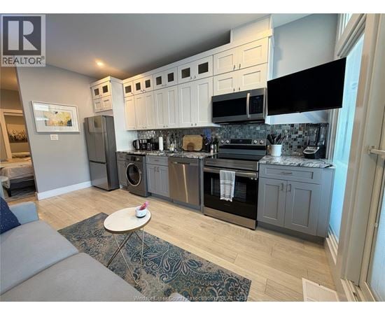 A kitchen with a grey and white color scheme.