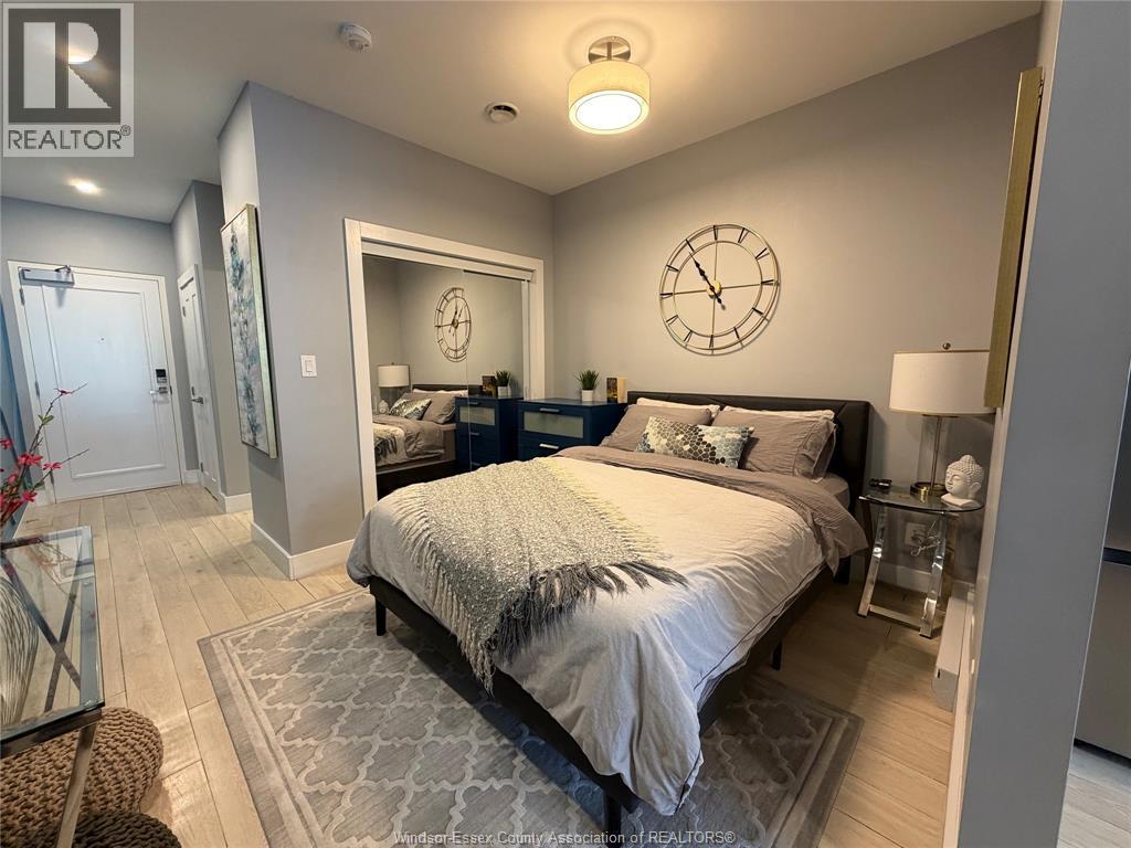 A bedroom with a large bed and a clock on the wall.
