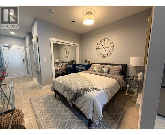 A bedroom with a large bed and a clock on the wall.