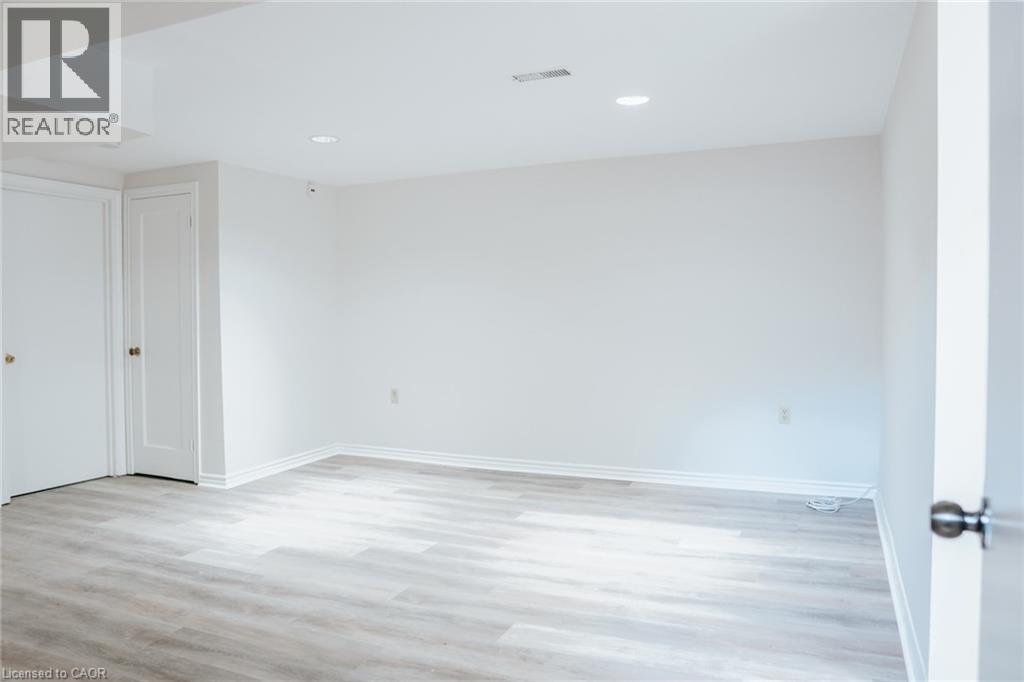 A spacious room with a wooden floor and white walls.