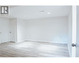 A spacious room with a wooden floor and white walls.