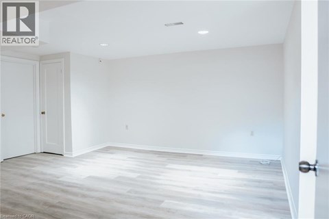 A spacious room with a wooden floor and white walls.