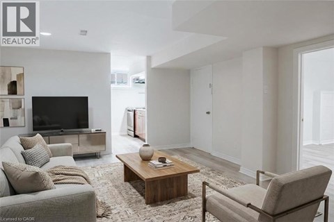 A living room with a grey couch, a wooden coffee table, and a television.