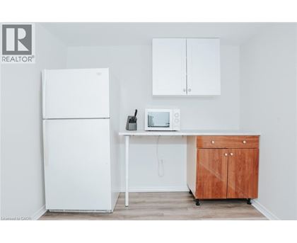 A white refrigerator is in a kitchen next to a wooden cabinet.