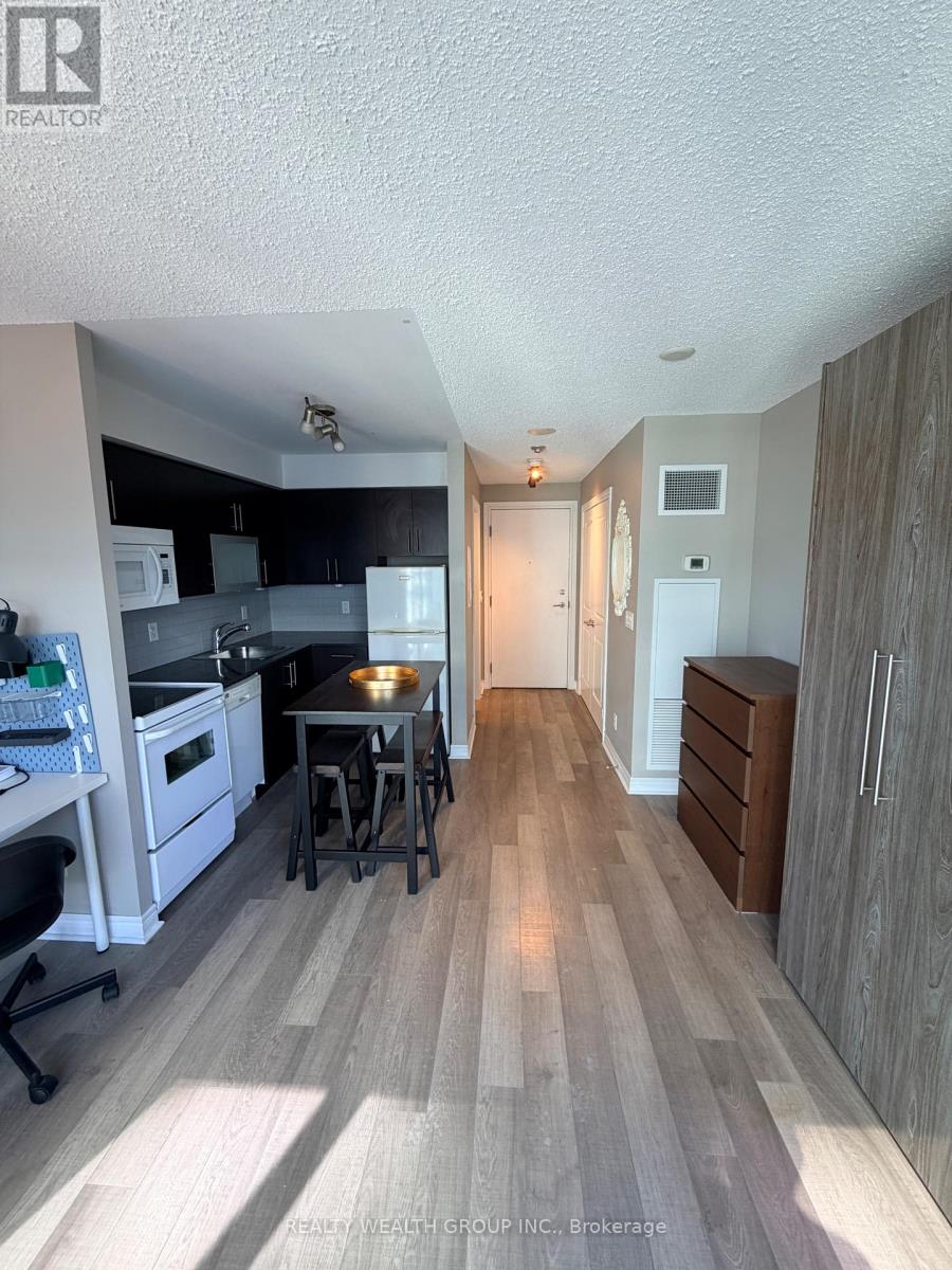 A kitchen with a dining table and chairs in the middle of the room.