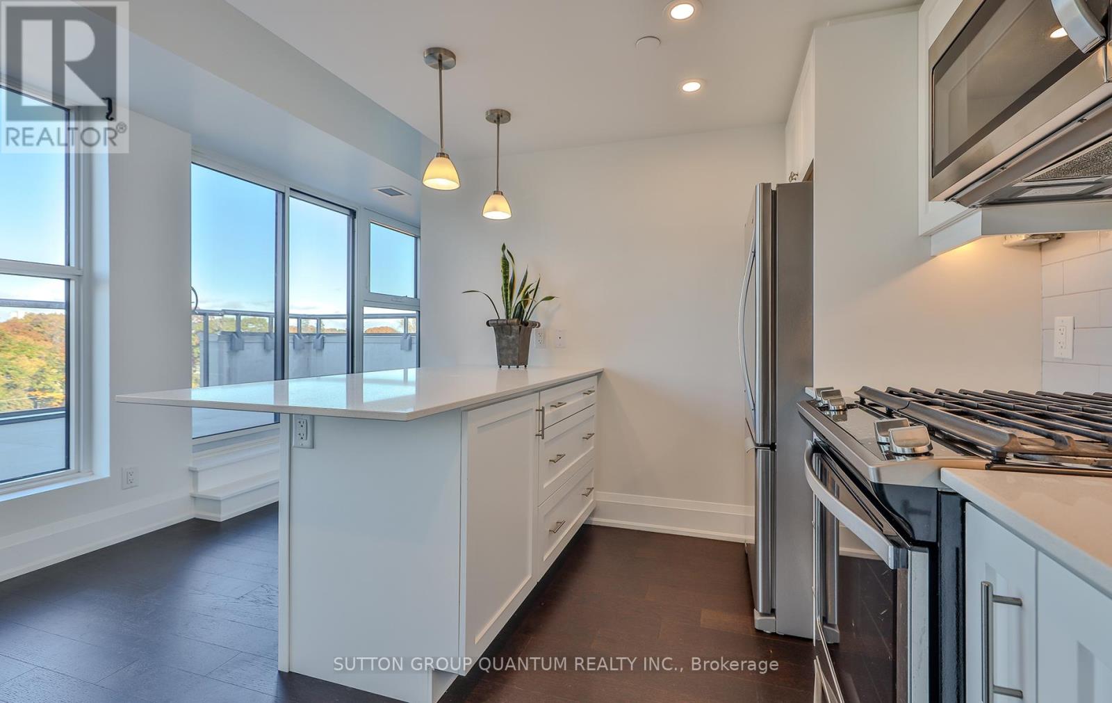 A kitchen with white cabinets and a stainless steel refrigerator.