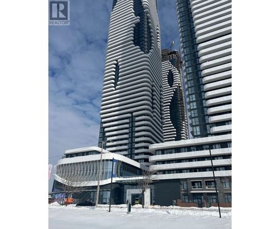 A tall building with a unique design stands next to a smaller building in a snowy landscape.