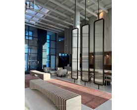 A modern interior space with a long bench and tall vertical panels.