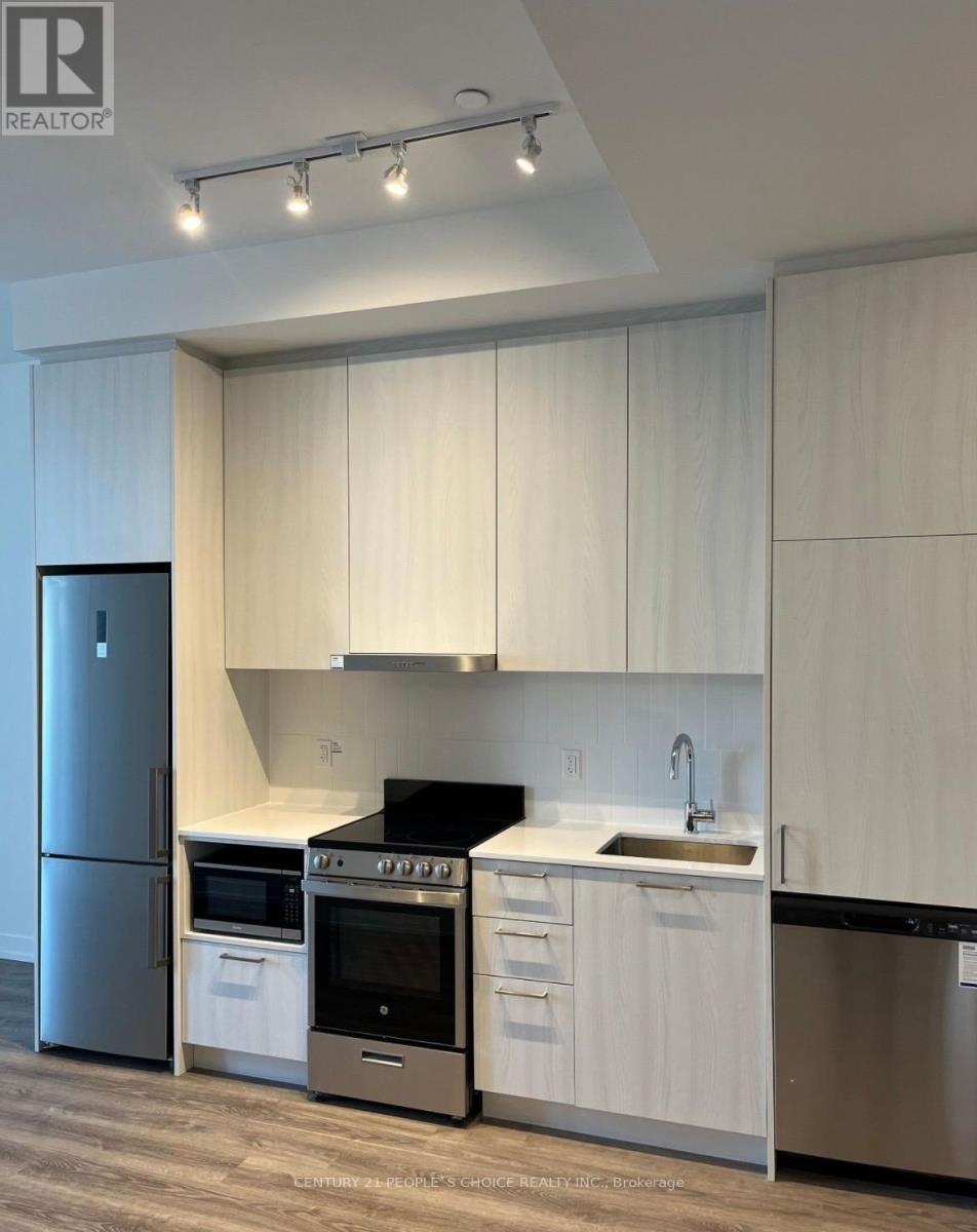 A modern kitchen with white cabinets and stainless steel appliances.