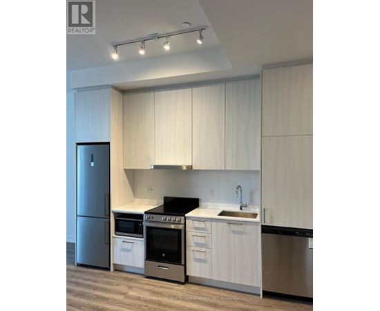 A modern kitchen with white cabinets and stainless steel appliances.