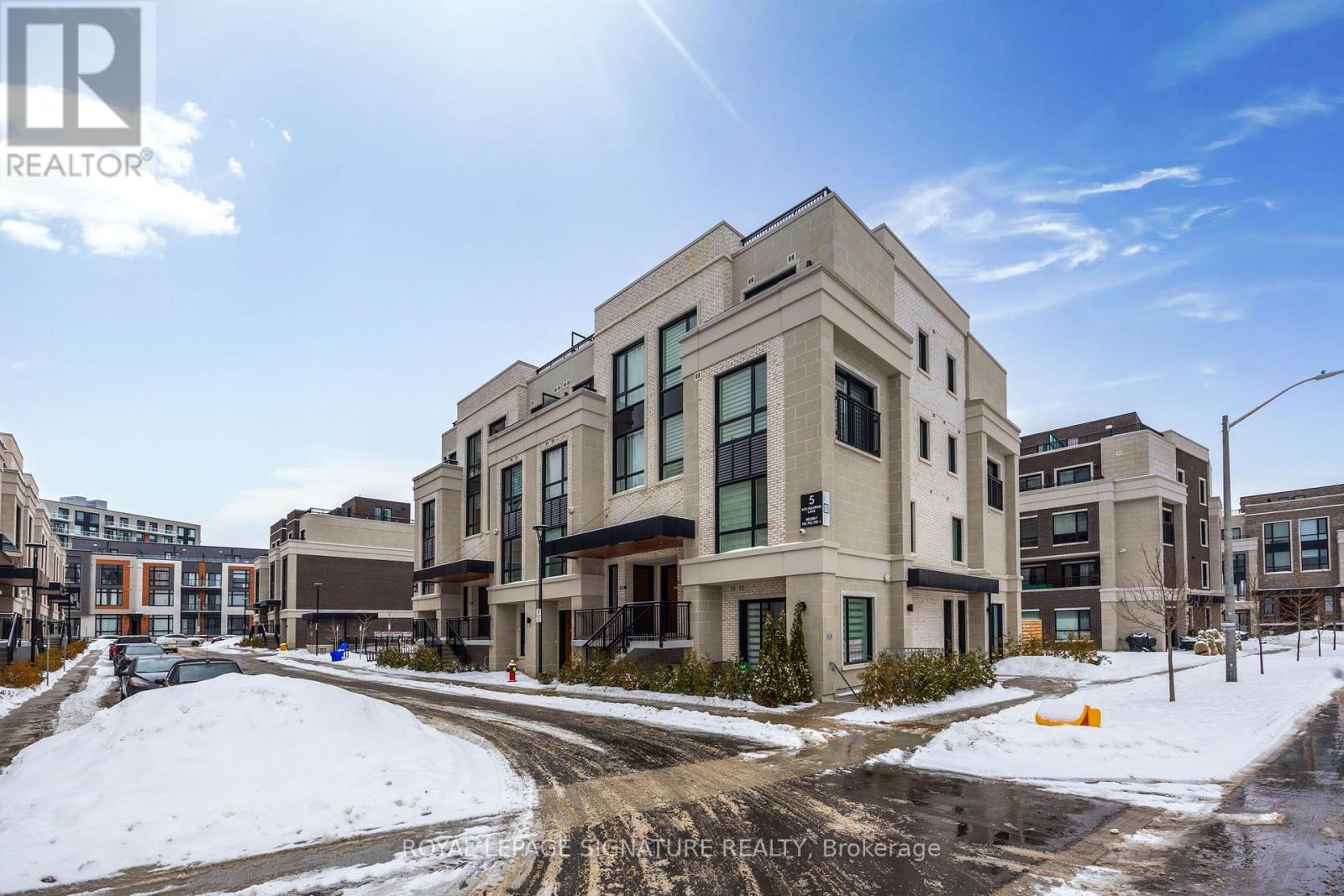 A sunny day in a residential area with a building in the foreground.